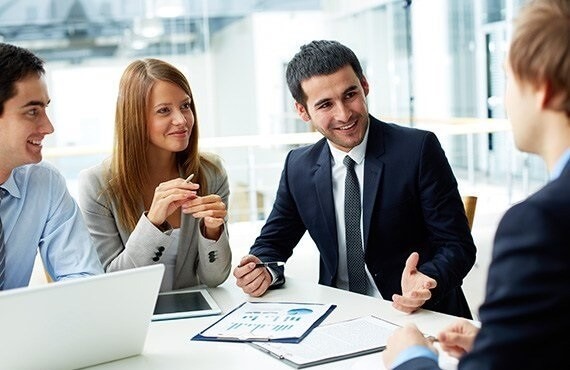A team of advisors reviewing a wealth plan together at a bright office table